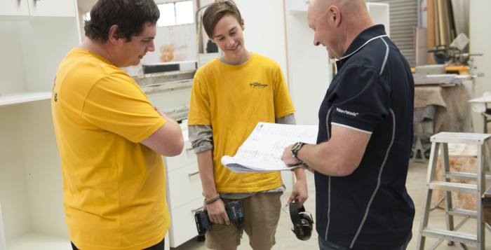 Apprentice joiners Alex Mott and Kaleb Halley go over the plans with Ken Monk